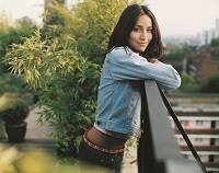 Photo of young woman leaning on outdoor balcony