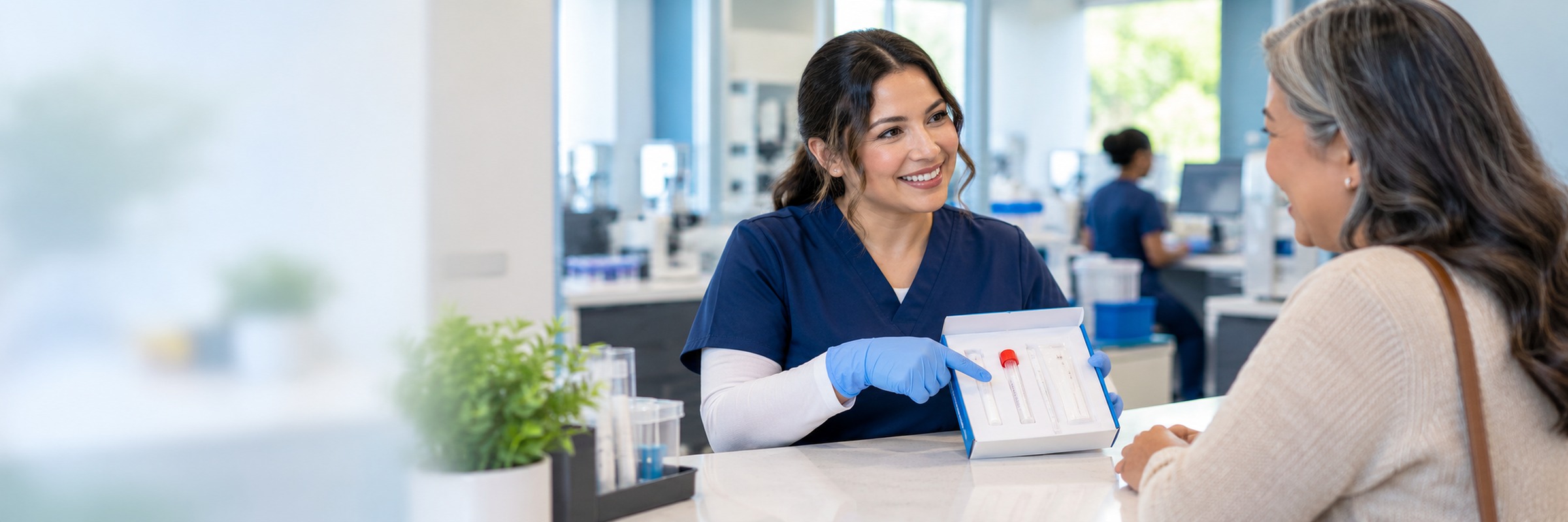 A lab staff member explaining a sample collection kit to a patient