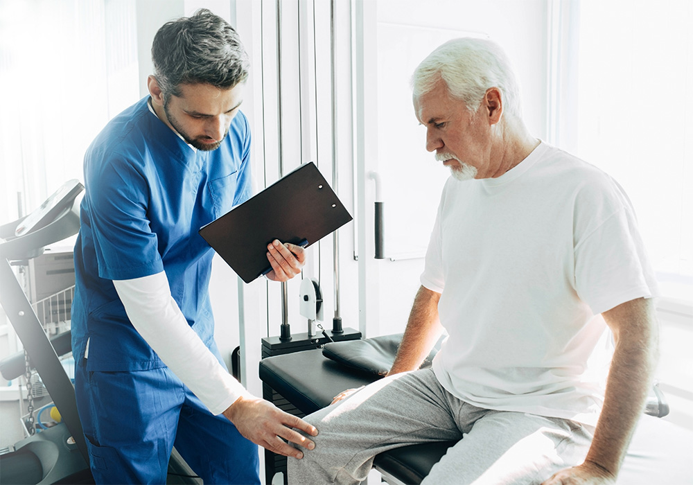 A nurse examining a patients knee in a doctors office